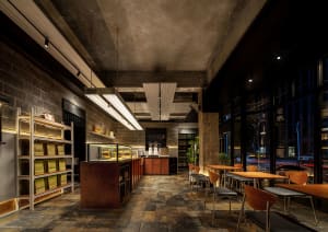 Interior of an industrial-themed coffee shop featuring concrete walls and floors.