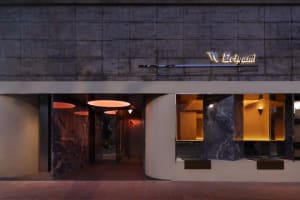 Modern storefront with concrete facade and illuminated signage.