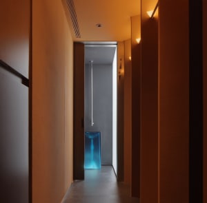 A modern interior hallway with metallic walls and lighting fixtures.