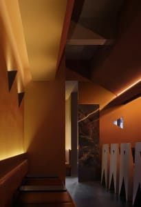 Modern restaurant interior with warm lighting and geometric shapes.