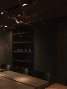 Minimalist restaurant interior featuring concrete and wooden elements.