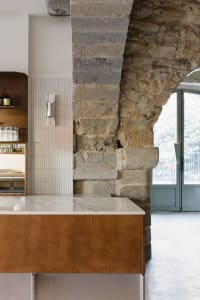 A modern restaurant bar counter featuring stone, marble, and wood materials