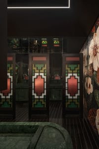 The front entrance of a modern restaurant featuring intricate stained-glass doors with geometric patterns.