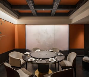Modern restaurant private dining room with fabric chairs and wooden table.