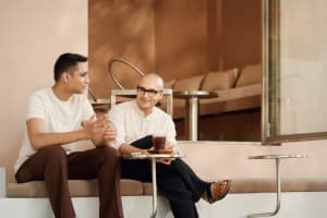 Two people sitting in a minimalist-designed coffee shop, engaged in a conversation.