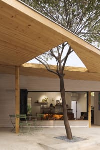 A modern coffee shop with wooden interior features and a large window allowing natural light to flood the space.