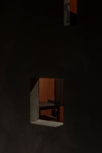 A minimalist interior space with a concrete wall and floor