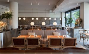 A modern coffee shop with wooden furniture and fabric booths.