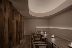 Modern restaurant interior with wooden tables and benches.