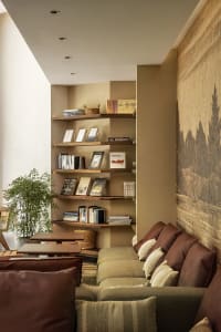 A modern living room featuring wooden shelves and upholstered seating.
