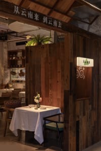 A cozy, industrial-style restaurant interior with wooden walls and a table setup.