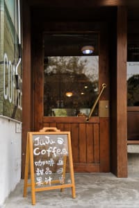 A wooden door with a glass window and a sign in front of it.