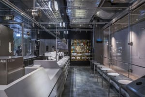 Industrial-style coffee shop with modern glass, concrete, and metallic materials.
