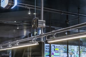 A modern storefront with a glass front, featuring industrial-style lighting and metallic accents.
