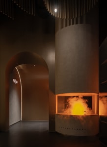 Modern living room with industrial concrete interior design, featuring a large fireplace with a warm, flickering flame and sm