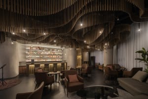 A modern bar and lounge area with a unique wooden ceiling design.