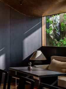 Modern residential lounge featuring metallic furniture and dark wood paneling