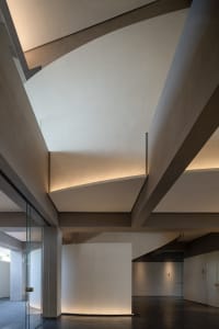 Modern, minimalist interior space featuring exposed concrete and glass materials.
