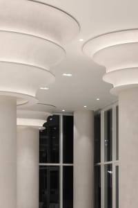 A corridor featuring decorative plaster columns illuminated by recessed lighting.