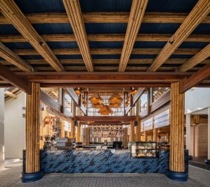 Modern coffee shop interior featuring a wooden bar and blue tiled flooring.