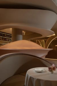 A modern restaurant interior with metallic architectural elements and futuristic design.