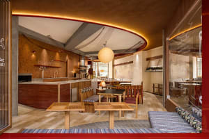 A modern restaurant interior featuring wooden furniture and a warm, inviting atmosphere.