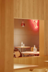 Modern cafe interior with wooden furniture and white walls.