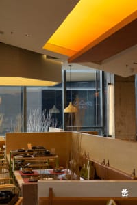 A modern restaurant interior featuring warm lighting and wooden elements.
