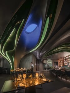 Luxurious modern restaurant interior with metallic ceiling and lighting features.