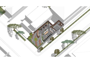 Industrial office space with concrete walls and floors, featuring open workstations and a central meeting area with tables an