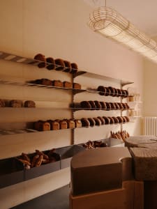 Industrial-style bakery with metal shelves displaying freshly baked bread on a concrete wall