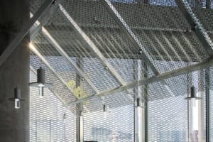 A modern, industrial office space featuring a grid ceiling made of metal.