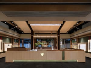 Modern interior design of a restaurant featuring concrete flooring, wooden tables, and glass displays.