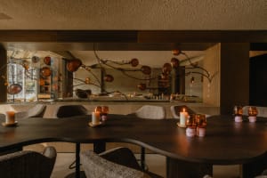 A modern restaurant interior with wooden furniture, glass fixtures, and a warm, inviting atmosphere