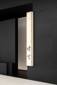 Modern minimalist white marble wall featuring Chinese characters on a black wall background.