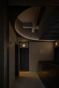Interior view of a minimalist lobby area featuring concrete walls and flooring.