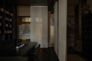 A traditional tea room featuring black tiles, wood accents, and fabric curtains.