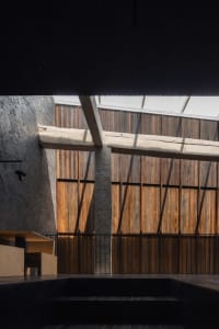 A modern architectural space featuring wooden panels and concrete structural elements.