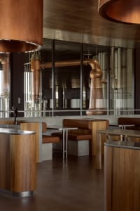 A modern restaurant bar featuring copper and wooden materials.