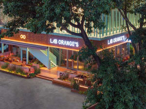 Modern restaurant exterior featuring metal cladding and greenery at night