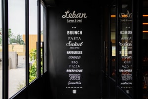 A black menu board featuring a list of food items in white text, including brunch, pasta, salad, hamburger, coffee, BBQ, pizz