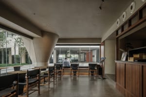 A contemporary lobby with concrete walls and floors, featuring minimalist design elements and a warm, inviting atmosphere.