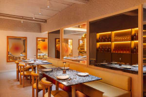 A modern restaurant interior featuring marble, concrete, and cork materials.