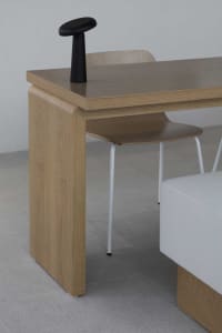 Modern minimalist office space featuring a wooden desk with white chair.