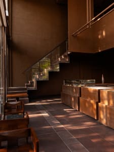 An image of a modern commercial space featuring natural light, wooden furniture, and concrete walls.