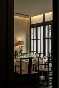 A well-lit, minimalist dining room with clear glass windows and modern furniture.