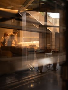 A restaurant interior with an industrial design featuring metallic furniture and an exhibit counter.