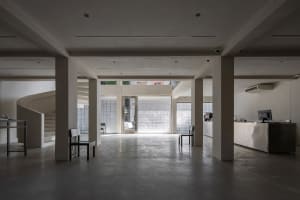 A minimalist coffee shop interior with concrete flooring and glass block walls.