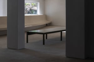 A minimalist interior featuring a metallic table with a sleek design.