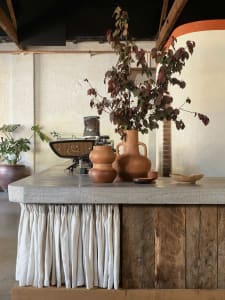 Industrial-style coffee shop counter with concrete surface and rustic wood paneling.